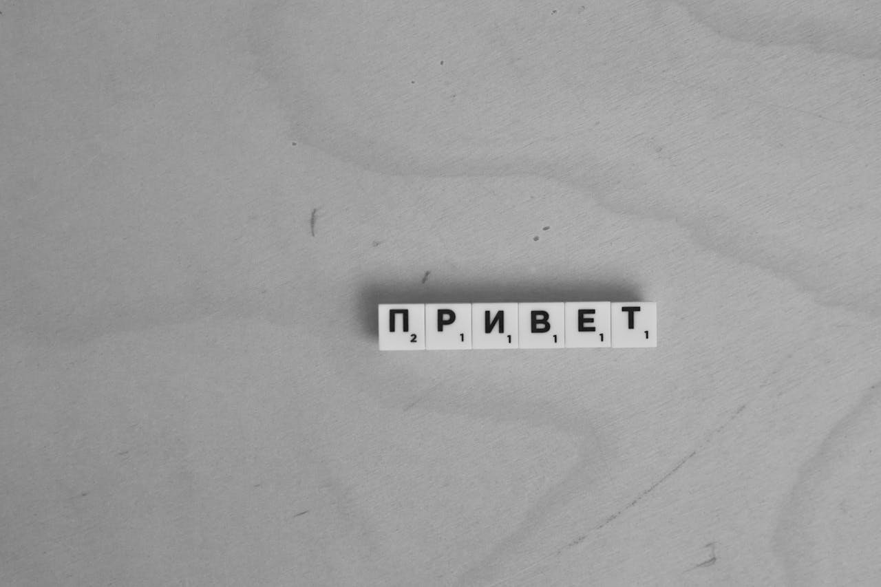 Scrabble letters spelling 'Привет' on a wooden surface, highlighting language diversity.